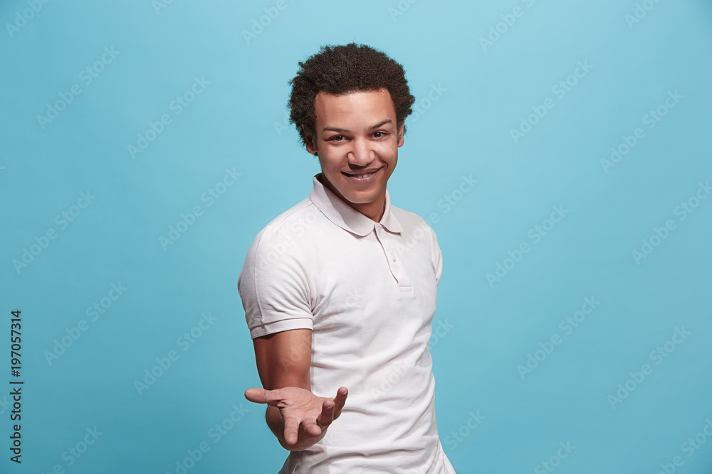 Beautiful male half-length portrait isolated on blue studio backgroud. The young emotional surprised man