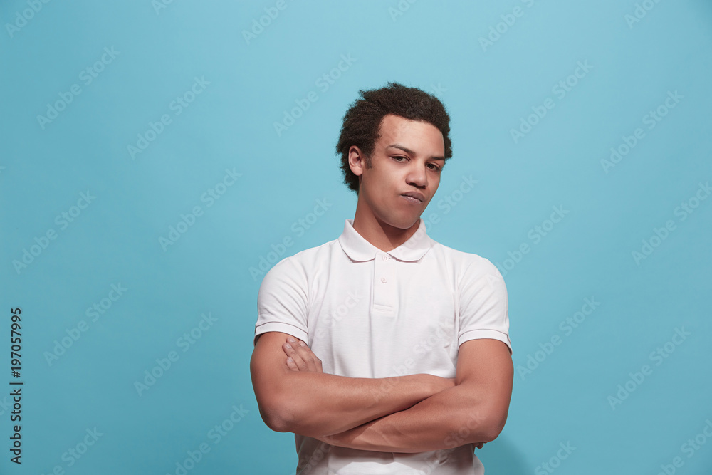 Suspiciont. Doubtful pensive man with thoughtful expression making choice against blue background Suspiciont. Doubtful pensive man with thoughtful expression making choice against blue background