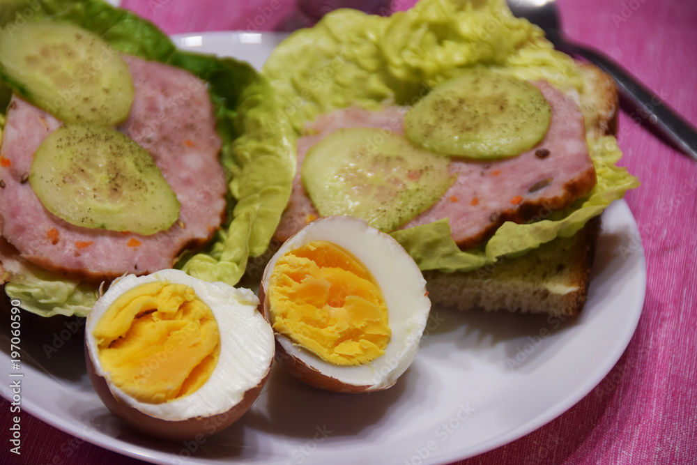 boiled egg, sandwiches with sausage and cucumber,