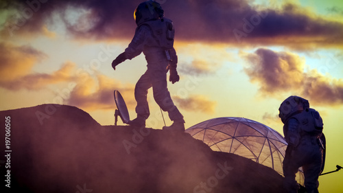 Fotografía Two Silhouettes of the Astronauts Explore Red Rocky Alien Planet