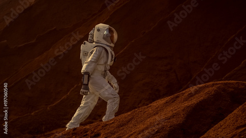 Astronaut Goes Up the Mountain to Explore Red Planet/ Mars. In the Background His Base and AI Powered Rover. Futuristic Colonization Concept.