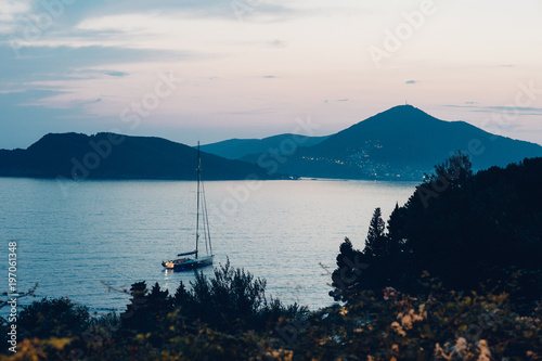 Sailing yacht at twilight in the bay . Adriatic Sea, Montenegro, Sveti Stefan