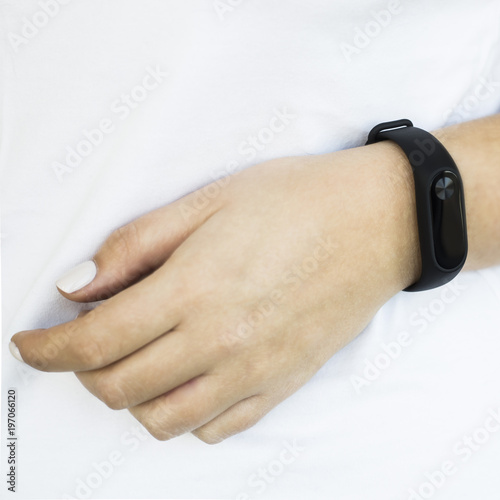 Woman In a white T-shirt with a fitness bracelet on her arm. Healthy lifestyle and fitness concept