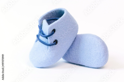 Blue handmade baby shoes made of merino wool on a white background.