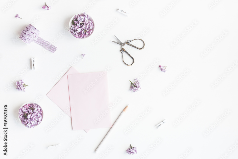 Flowers composition. Paper blank and lilac flowers on white background. Flat lay, top view, copy space Flowers composition. Paper blank and lilac flowers on white background. Flat lay, top view, copy space