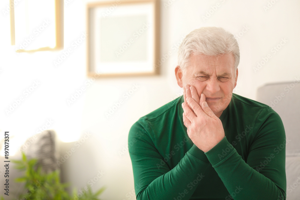 Mature man suffering from toothache at home Mature man suffering from toothache at home