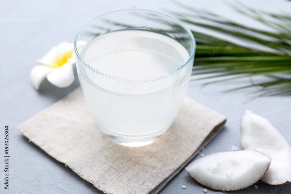 Glass of coconut water on table, closeup