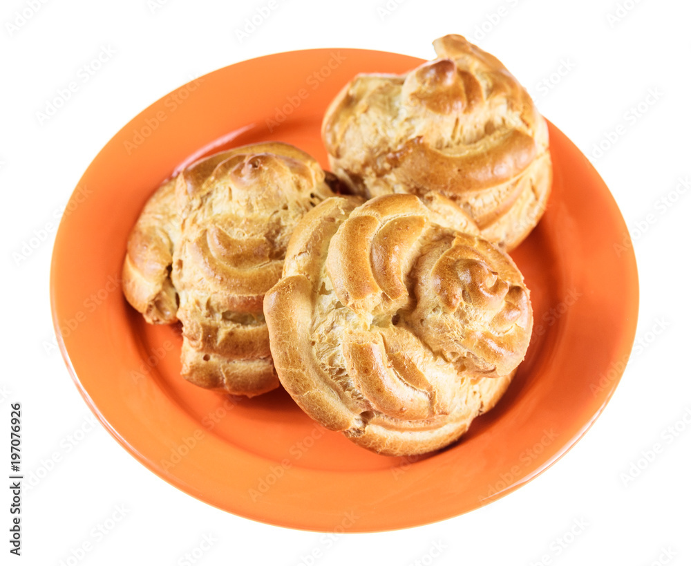 home eclairs on an orange plate isolated on a white background