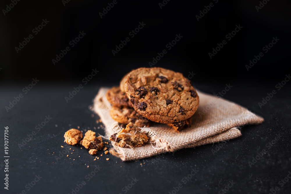 Fototapeta premium Chocolate cookies on linen napkin on black background. 