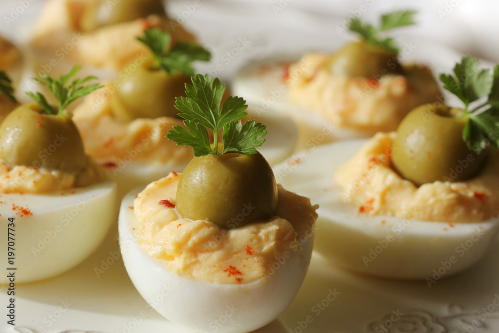 Spicy deviled eggs garnished with green olives and parsley Spicy deviled eggs garnished with green olives and parsley