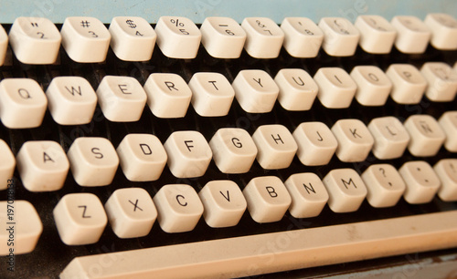 Old fashioned technology concept. Closeup of an old white typewriter keys. Qwerty keyboard.