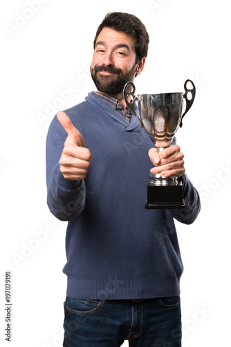 Happy Handsome brunette man with beard holding a trophy on white background