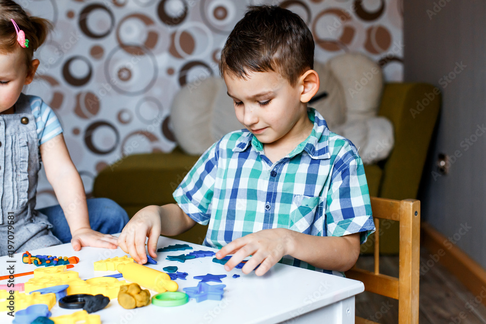 Picture of a boy playing with color play dough and cutters. Having fun with colorful modeling clay. Creative kids molding at home. Children play with plasticine or dough. Picture of a boy playing with color play dough and cutters. Having fun with colorful modeling clay. Creative kids molding at home. Children play with plasticine or dough.