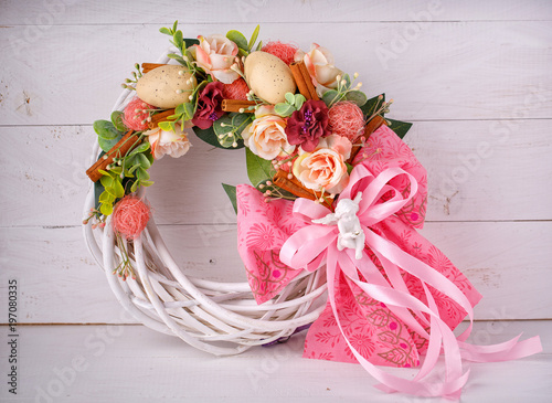 Fotografie Decorative woven wreath is decorated with flowers and quail eggs.