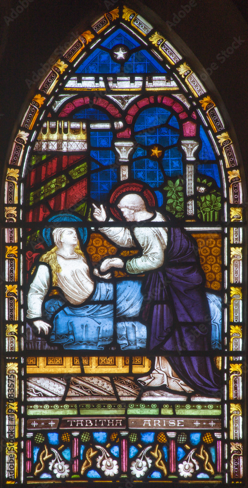 LONDON, GREAT BRITAIN - SEPTEMBER 19, 2017: The Raising of Tabitha on the stained glass in St Mary Abbot's church on Kensington High Street.
