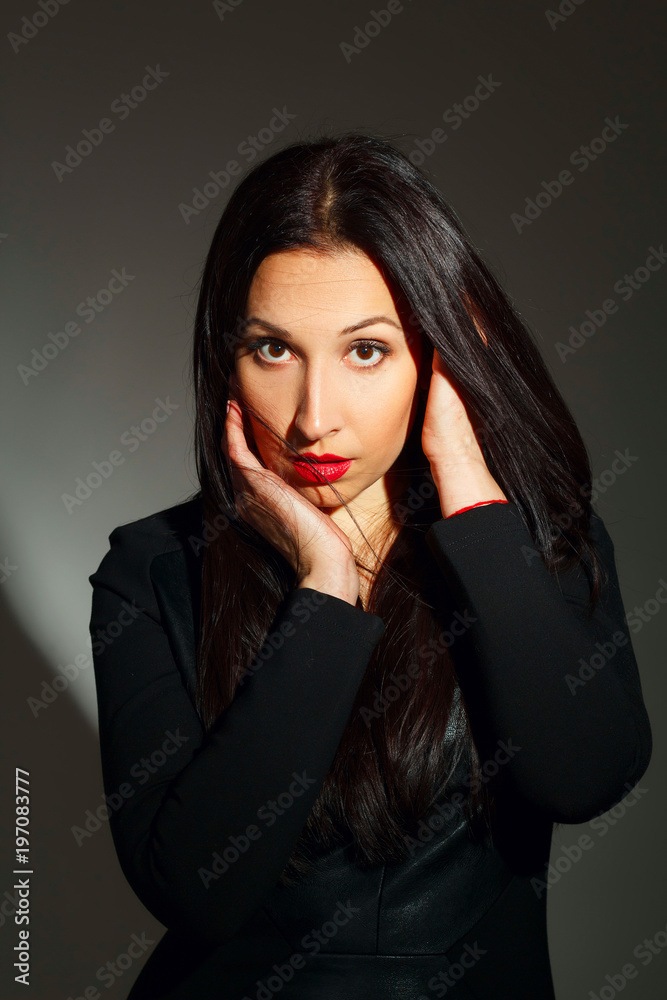 Portrait of young beautiful woman with red lipstick over dark background. Beauty portrait concept. Portrait of young beautiful woman with red lipstick over dark background. Beauty portrait concept.