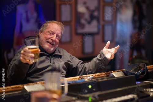 Elderly Bar Patron Having An Alcoholic Drink Smiling