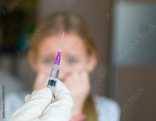 Fear of injections, the child with the nurse.The girl in the treatment room.The girl is crying. photo