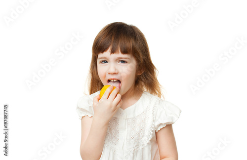 Girl 4-5 years crooked and eating lemon on white background