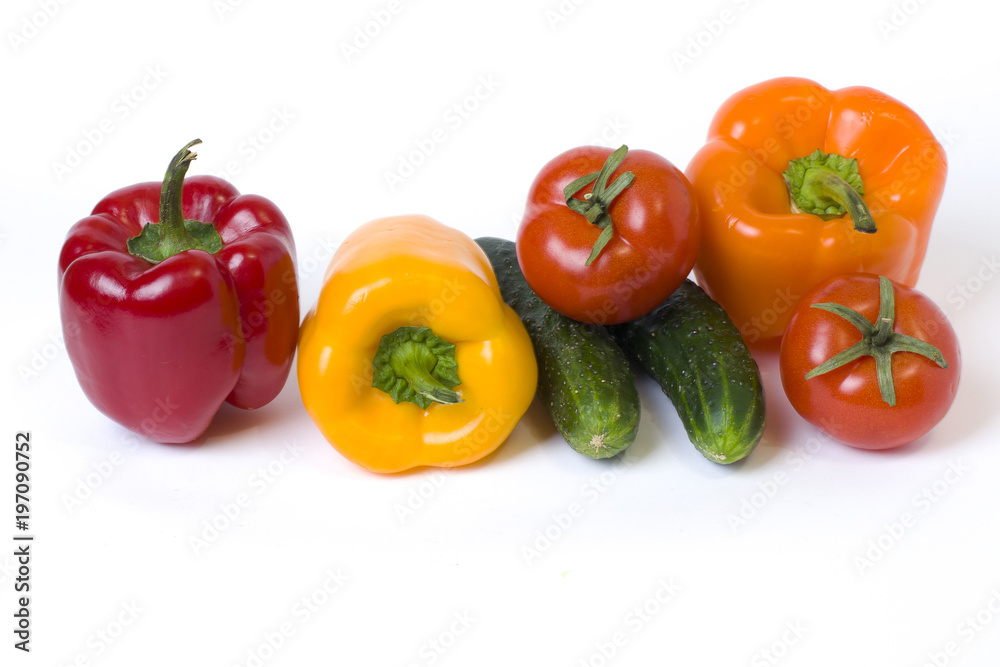 Red yellow and orange peppers with tomatoes on a white background. Cucumbers with colorful peppers in composition on a white background.