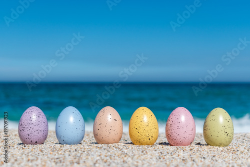 Fototapeta Naklejka Na Ścianę i Meble -  Colorful Easter eggs on the beach in sunny day. Easter concept.