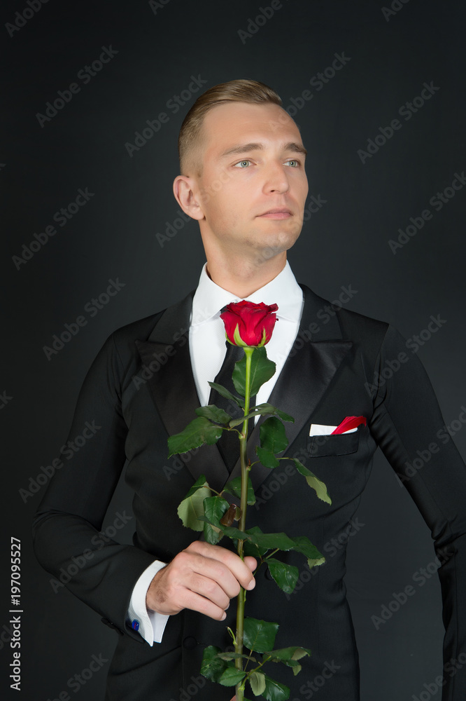 Man in suit with rose on dark background Man in suit with rose on dark background
