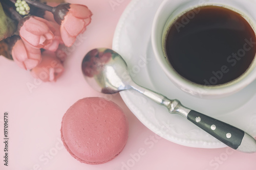 Pink macaron, macaroon, spring flowers and coffee, pastel background, top view. Romantic morning, gift for beloved