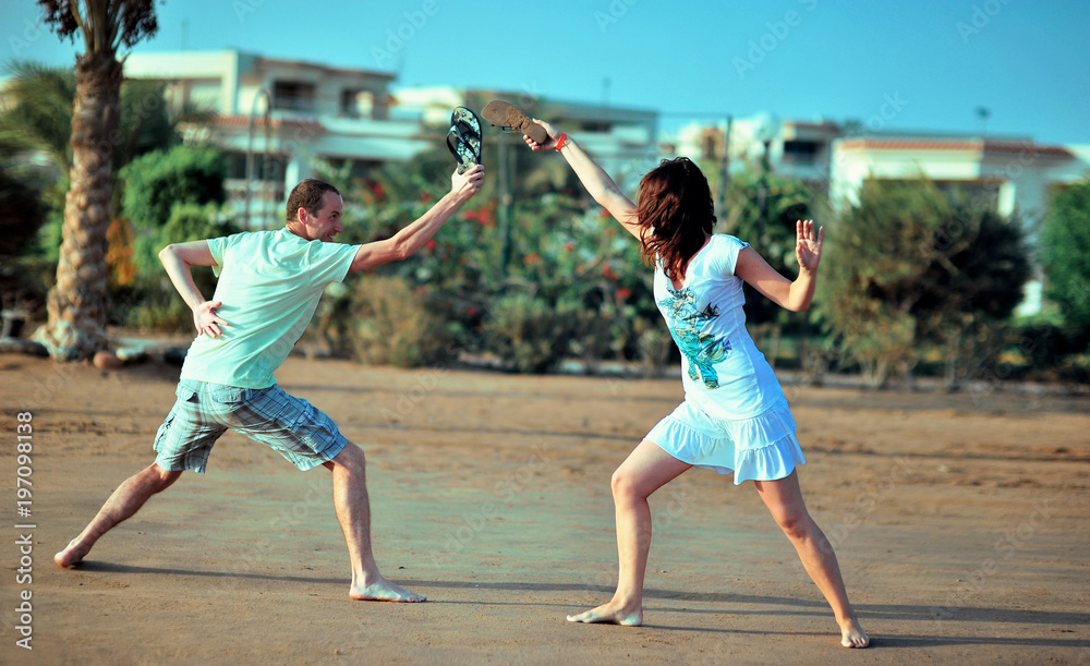 Happy young couple having beach fun on vacation honeymoon travel holidays. Caucasian woman and man playing playful enjoying love on date or honeymoon. Multiracial couple