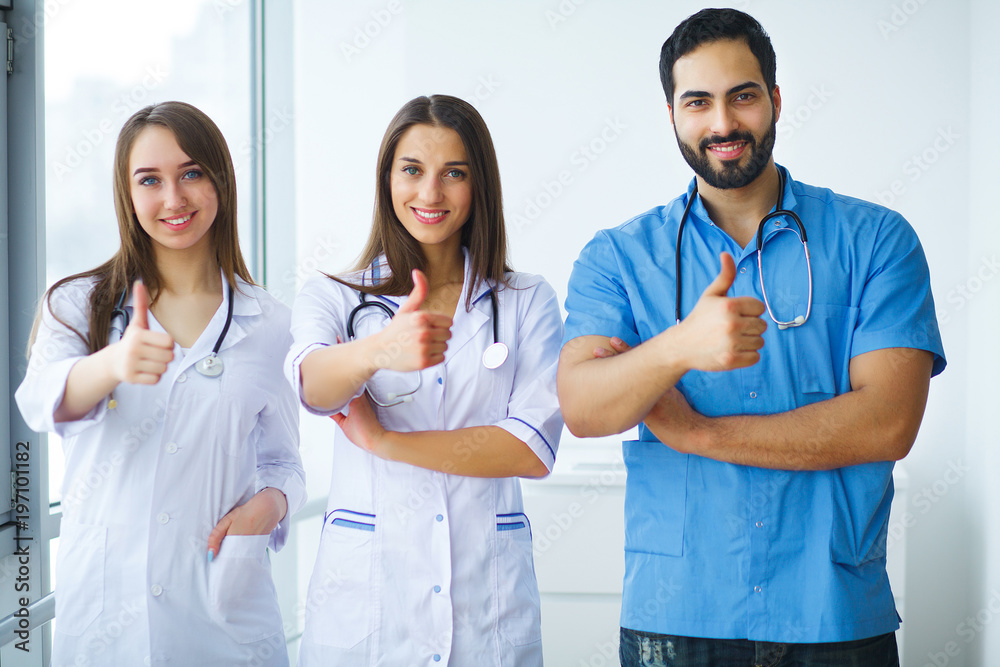 Portrait of medical team standing with arms crossed in hospital