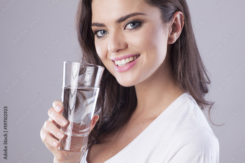 Young woman with beautiful smile is drinking water. Young woman with beautiful smile is drinking water.