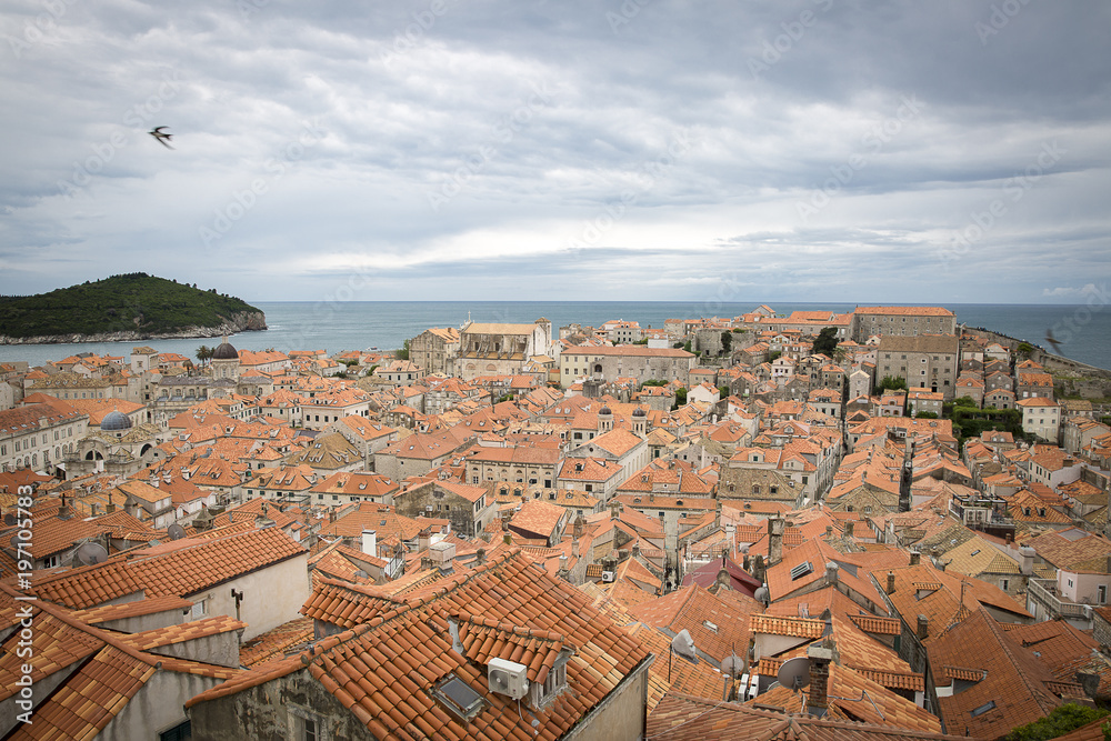View over the orange rooftops of old town Dubrovnik from the ancient city wall with cloudy weather, Croatia View over the orange rooftops of old town Dubrovnik from the ancient city wall with cloudy weather, Croatia