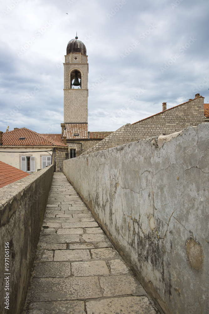 walkway path on the old city wall of Dubrovnik, Croatia with view on the cityscape and Dubrovnik City Bell Tower