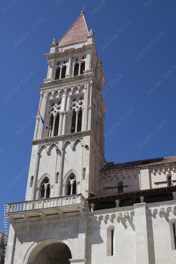 Bell tower of the Cathedral of St. Lawrence with blue sky in the background, Trogir, Croatia,  built in the Romanesque-Gothic style