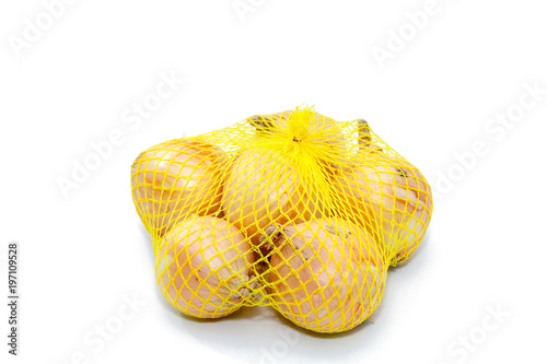 Fresh onions in a yellow plastic net