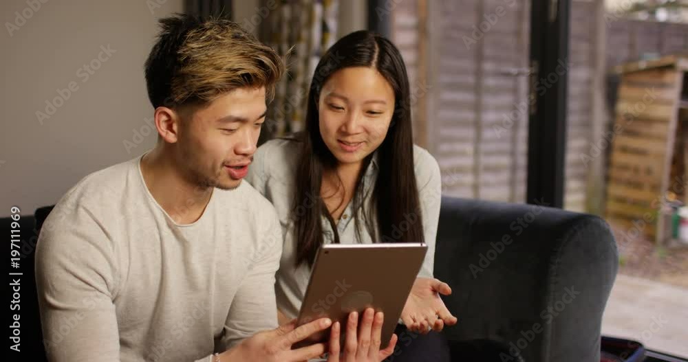 4K Happy Asian couple browsing the internet at home & chatting. Slow motion. 4K Happy Asian couple browsing the internet at home & chatting. Slow motion.