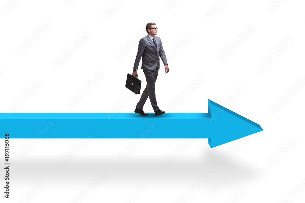Businessman walking on arrow in business concept Businessman walking on arrow in business concept