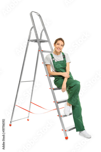 Young female decorator with ladder on white background