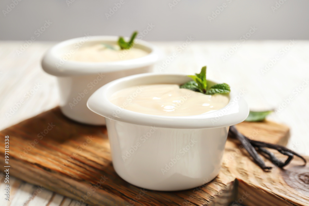 Vanilla pudding, sticks and fresh mint on wooden board Vanilla pudding, sticks and fresh mint on wooden board