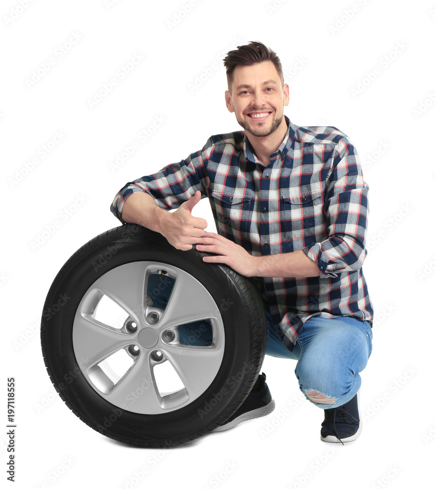 Young man with car tire on white background