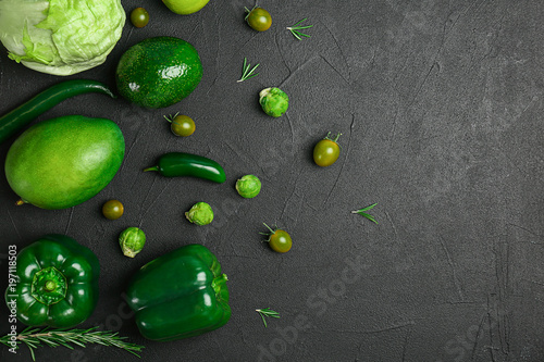 Fototapeta Naklejka Na Ścianę i Meble -  Different green vegetables and fruits on dark background, top view