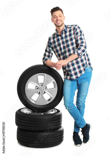 Young man with car tires on white background