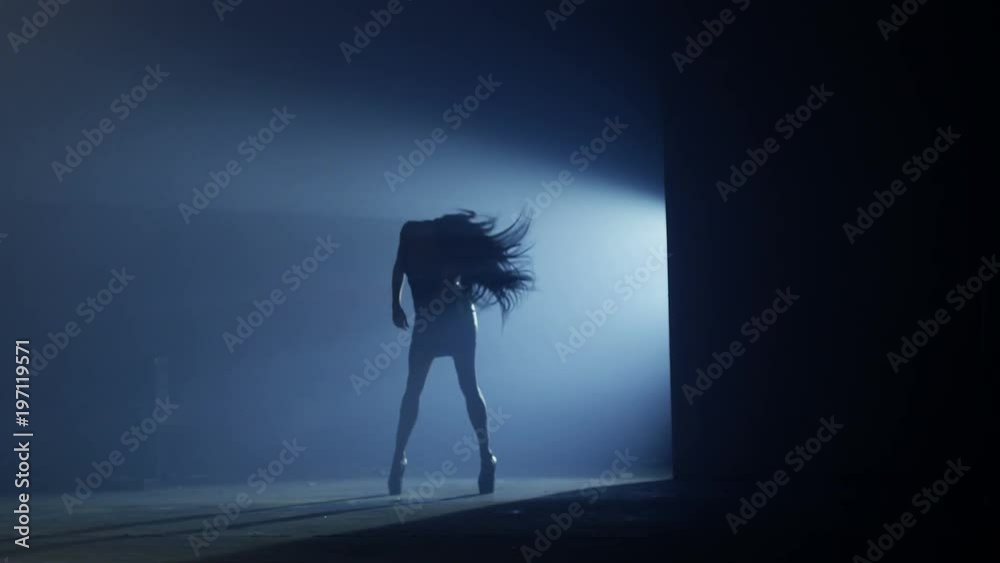Beautiful dancer demonstrating her perfect sensual figure and dancing on dark blue background with strobe light effect . Shot on RED HELIUM Cinema Camera in slow motion.