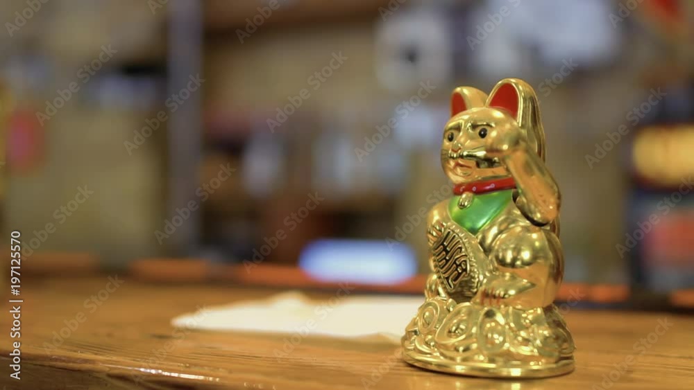 Waving maneki neko on bar counter in Korean restaurant Waving maneki neko on bar counter in Korean restaurant