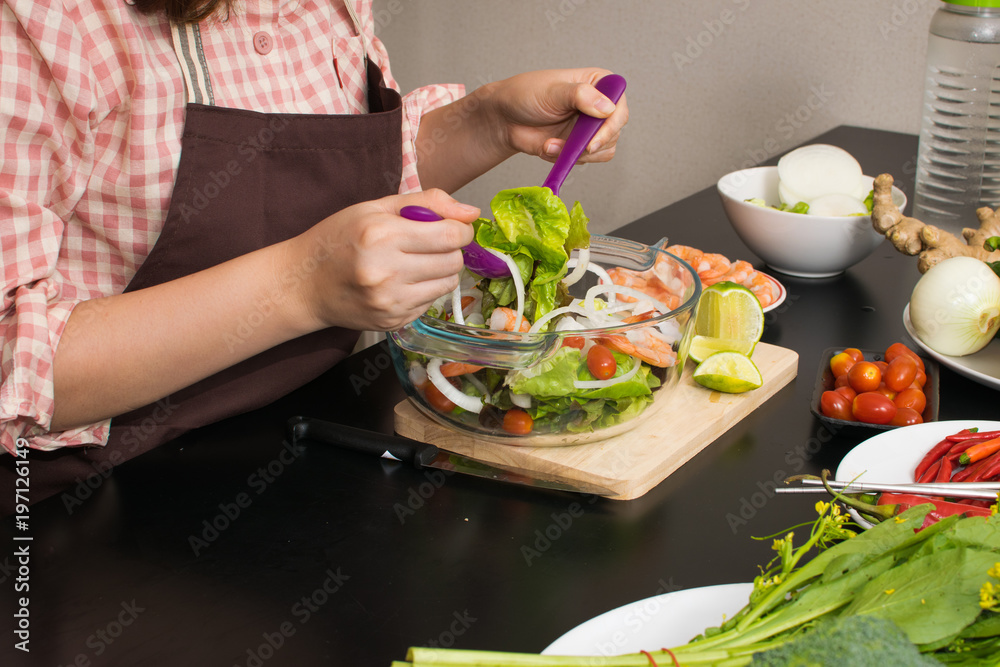 beautiful woman cooking in new kitchen making healthy food with vegetables. beautiful woman cooking in new kitchen making healthy food with vegetables.