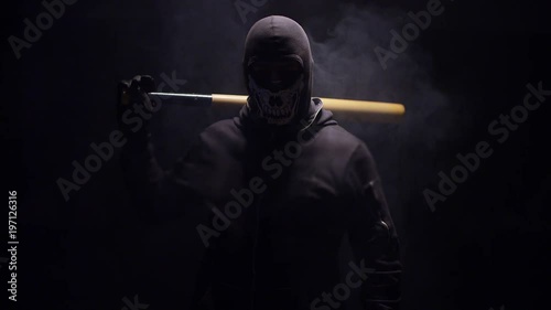 Portrait of masked hooligan with baseball bat on black background . Shot on RED cinema camera  photo