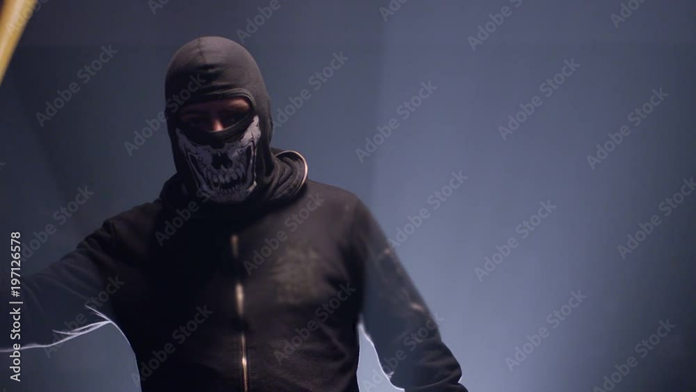 Portrait of bandit with mask and baseball bat on dark room. Shot on RED cinema camera Portrait of bandit with mask and baseball bat on dark room. Shot on RED cinema camera