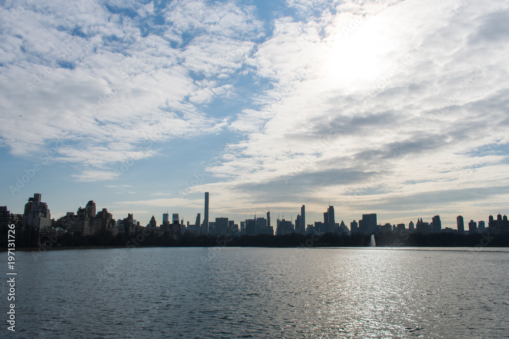 New York City skyline over a lake with awesome clouds