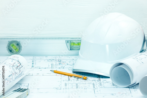 technical plan, blueprint rolls, pencil, bubble level, protective helmet on architect workplace. construction background 