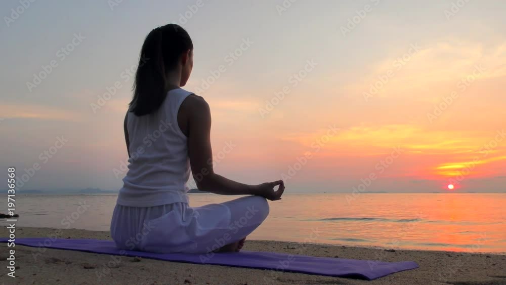 Young Woman Meditates at Sunset Sea. Girl Ptactice Meditation on the Beach at Sunset. Relaxing Alone Young Woman Meditates at Sunset Sea. Girl Ptactice Meditation on the Beach at Sunset. Relaxing Alone