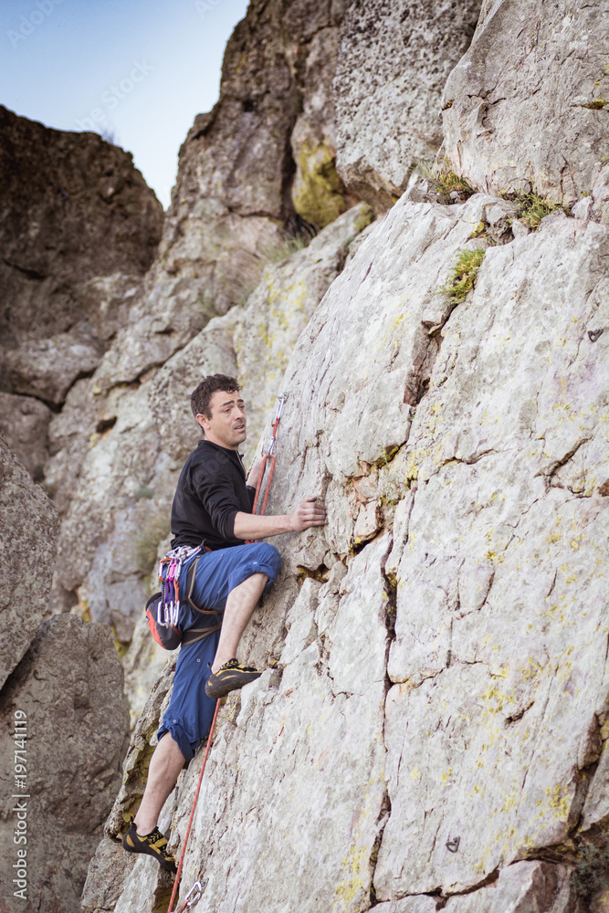 man climbing a rock wall